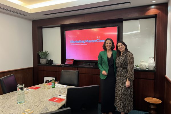 Marketing Masterclass at Servcorp with Ultimate Edge Communications Founder & CEO, Aleisha McCall, stands in front of a projector with an event attendee